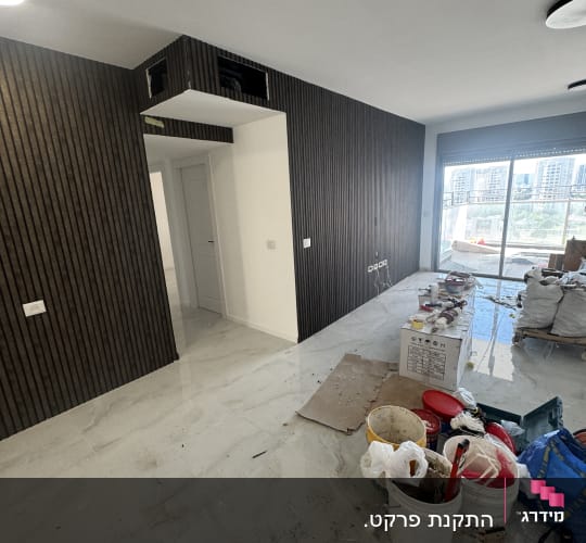 חדר עם קירות עץ כהים וכלי עבודה על הרצפה